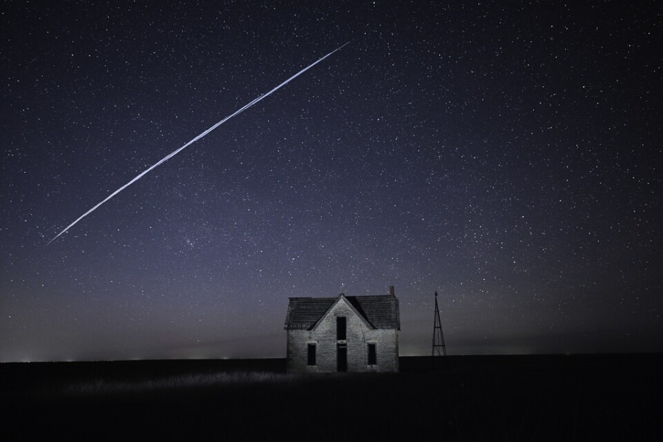 Den här bilden, tagen med lång slutartid, uppges visa en Starlinksatellit som passerar över ett hus i amerikanska Kansas.