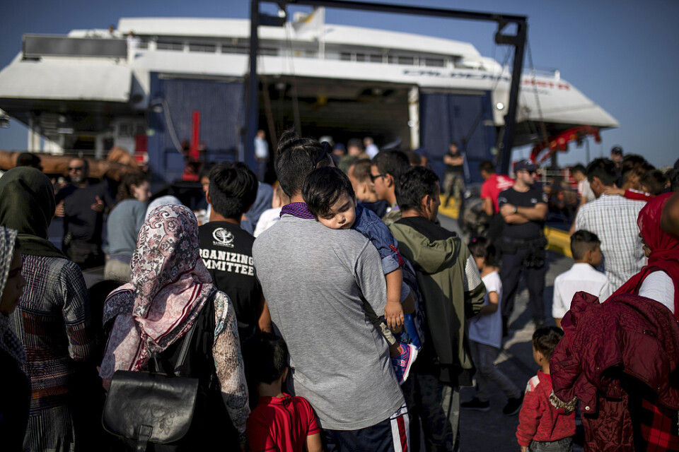 En man från Afghanistan bär sin dotter ombord en färja till fastlandet från Lesbos.