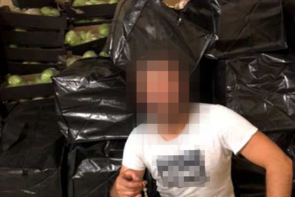 Här poserar den nu dömde 34-årige Växjöbon i en lagerlokal i Rottne bland säckar med isbergssallad, där polisen hävdar att det även fanns 248 kilo cannabis. Bilden togs efter den första leveransen den 1 augusti 2020 och hittades av polisen sedan en krypterad app knäckts.