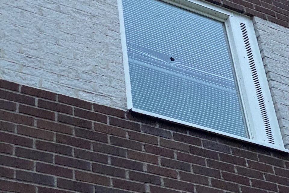 Ett, vad det ser ut som, kulhål, i fönsterrutan på lägenheten.