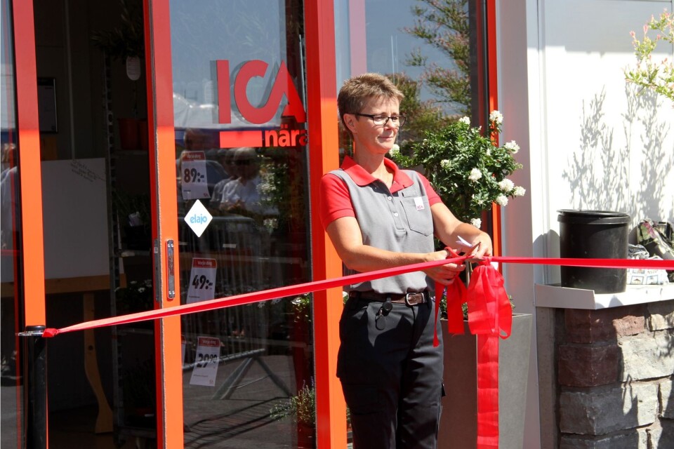 Yvonne Lind klipper det röda bandet framför entrén och därmed är den nya butiken invigd.