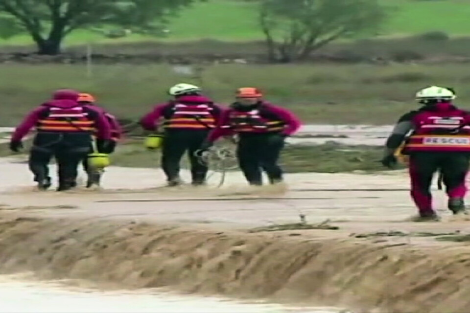 Personal från räddningstjänsten nära platsen där två personer omkom i en vattenfylld bil sydost om staden Valencia.