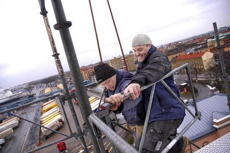 Martin Fribing och Stefan Hansson kommer att jobba på taket på det gamla stationshuset i hamnen fram till september. Bild: Sanna Trygg