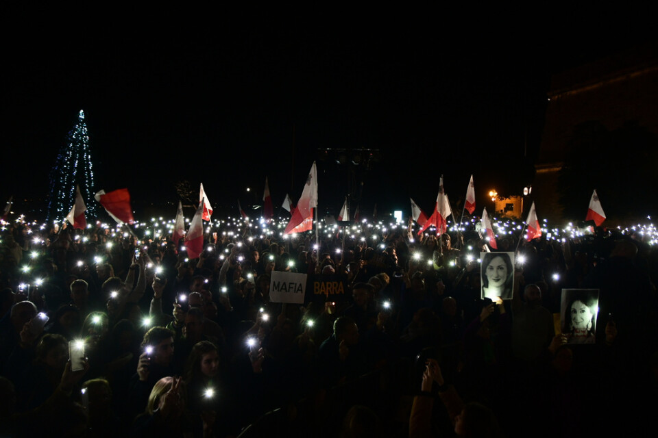 Demonstranter håller upp bilder av den mördade journalisten Daphne Caruana Galizia vid en demonstration utanför premiärministerns kansli på tisdagen.
