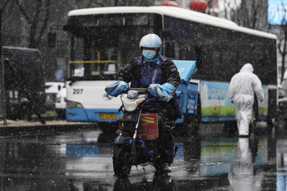 Ett bud med munskydd på väg ut med en leverans i Wuhan, centrum för virusutbrottet.