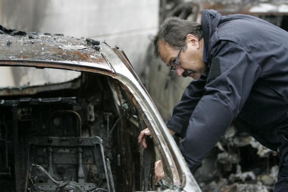 Kenneth Svensson, kriminaltekniker, undersöker ett av fordonen där branden startade. Foto: Lars-Åke Green