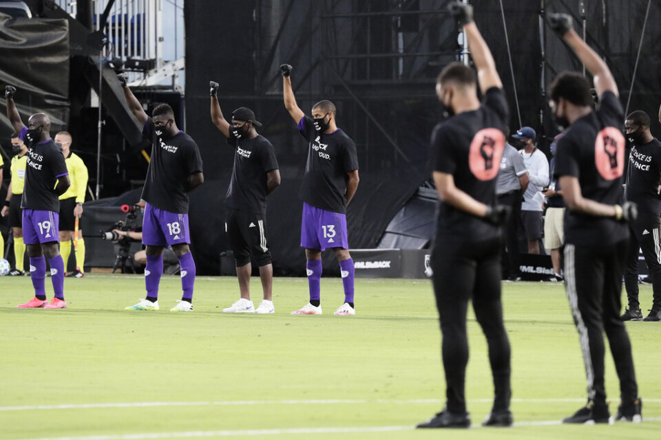 Orlandos spelare, till vänster, höjde sina nävar i protest mot rasistiskt våld före matchen.