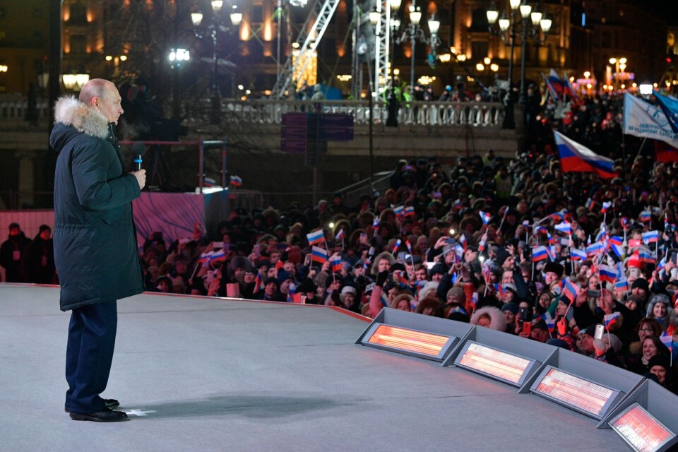 Rysslands president Vladimir Putin talar från en scen i centrala Moskva efter att ha vunnit valet på söndagen.