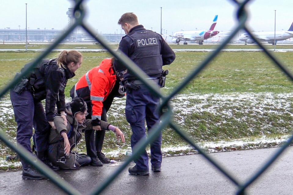 Polis försöker lyfta bort en klimataktivist från gruppen Sista generationen från en väg på Berlin Brandenburgs flygplats den 8 december.