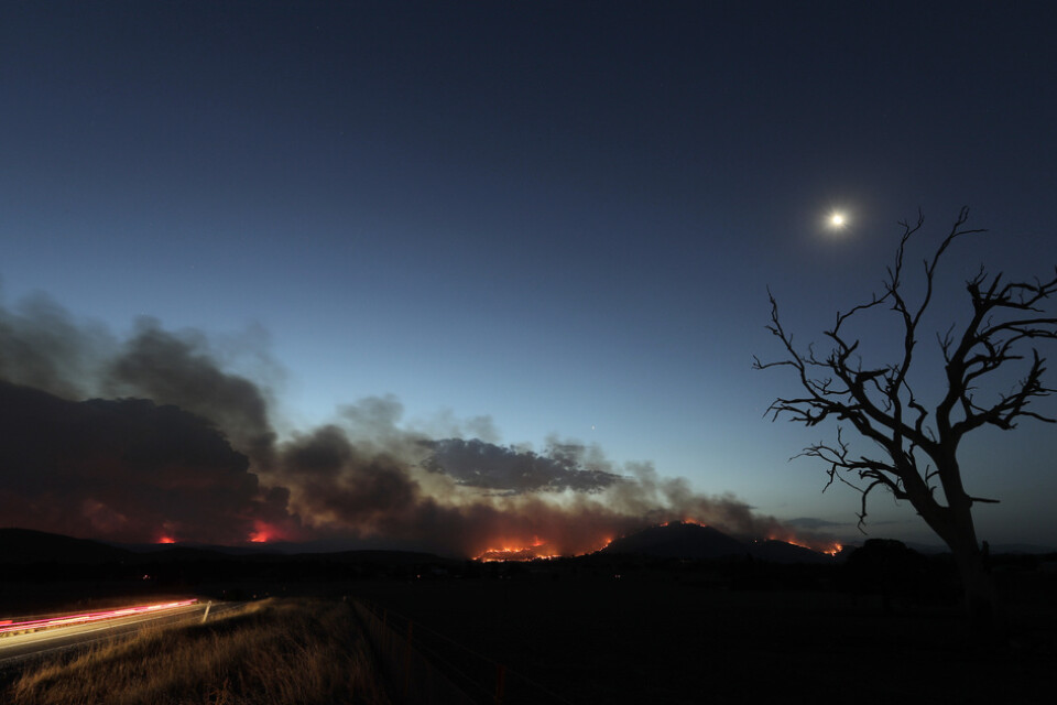 Clear Range-branden har vuxit i styrka, till följd av höga temperaturer. På bilden syns den söder om huvudstaden Canberra på fredagskvällen.