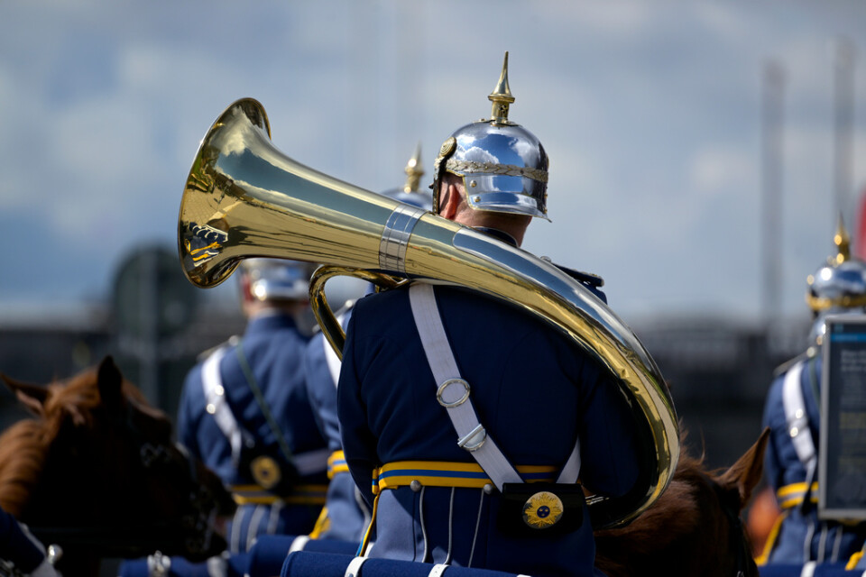 Den beridna högvakten passerar med sina spetsiga paradhjälmar och uniformer från 1800-talet, på Strömgatan på sin väg mot Stockholms slott.