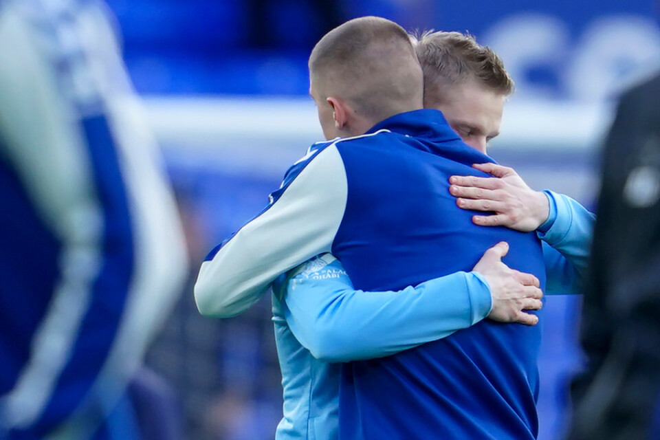 Oleksandr Zintjenko, i ljusblått, och Vitalij Mykolenko omfamnar varandra inför avspark mellan Everton och Manchester City.