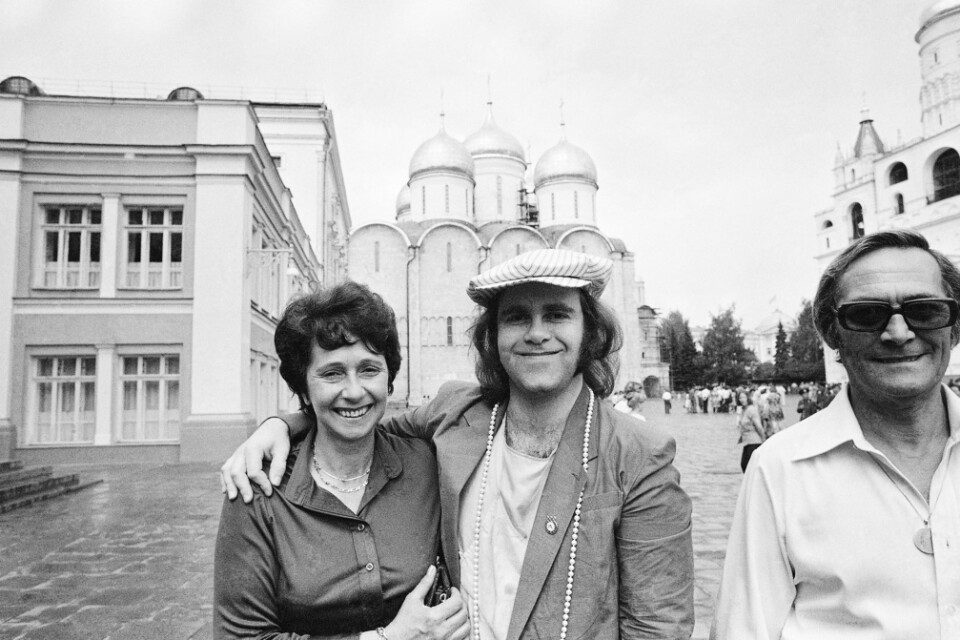 Elton John håller om sin mamma Sheila på Röda torget i Moskva 1979. Till höger om dem står Sheilas make Fred Farebrother. Arkivbild.
