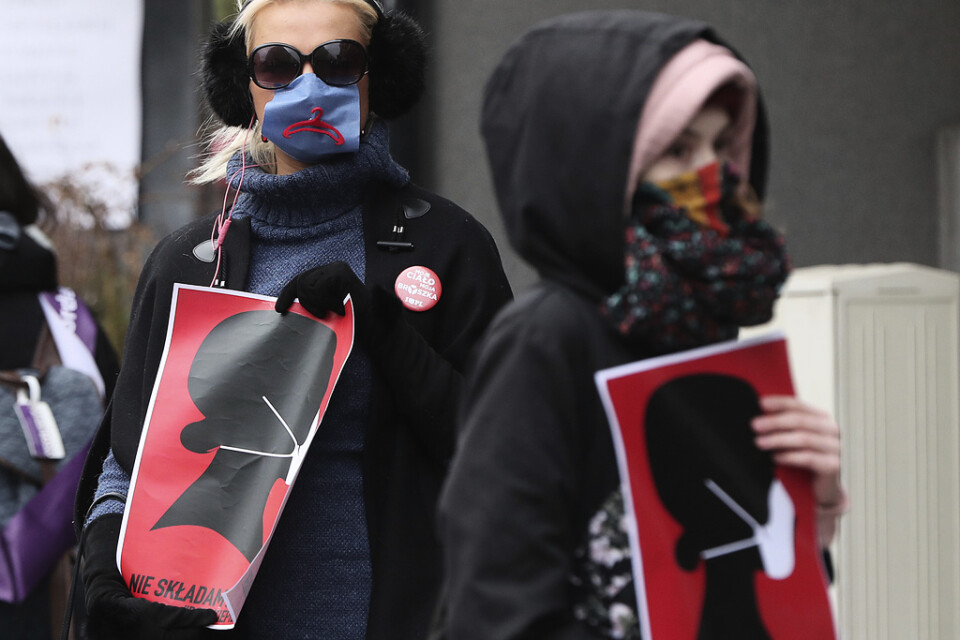 Kvinnorättsaktivister i munskydd demonstrerar mot den polska regeringens åtgärder i Warszawa. Arkivbild.