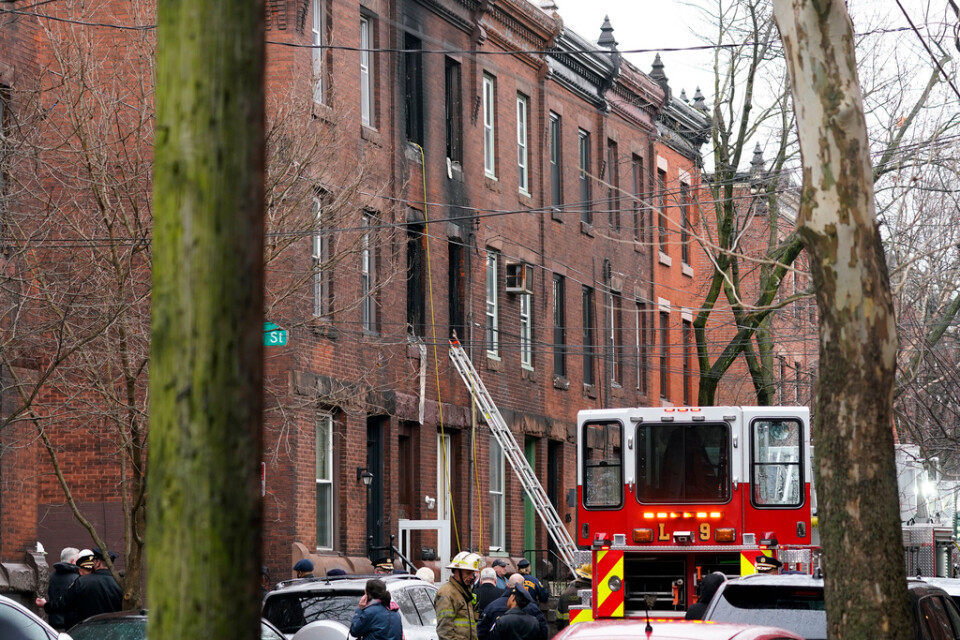 Philadelphias räddningstjänst på plats vid det eldhärjade hus där 13 människor, varav flera barn, miste livet på onsdagen.