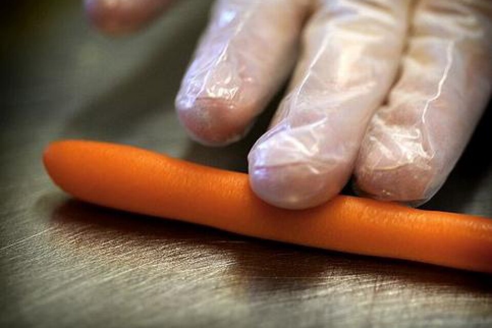 2. Rulla en smal pinne av den orangea marsipanen. Använd tunna gummihandskar så blir marsipanen alldeles slät och utan fingeravtryck. Dela sedan pinnen i tre delar.