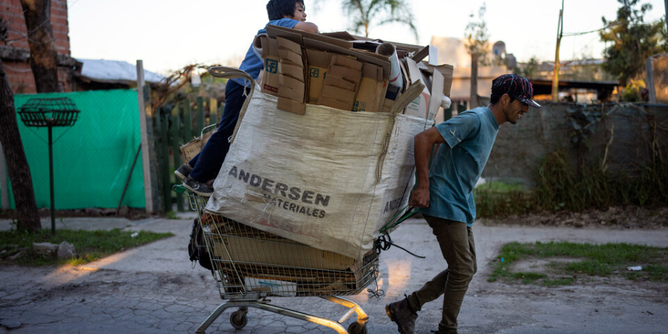 Jonathan Palacios och hans då åttaåriga son som också heter Jonathan, drar en kundvagn med kartonger de hoppas kunna sälja i Buenos Aires i en bild från augusti.