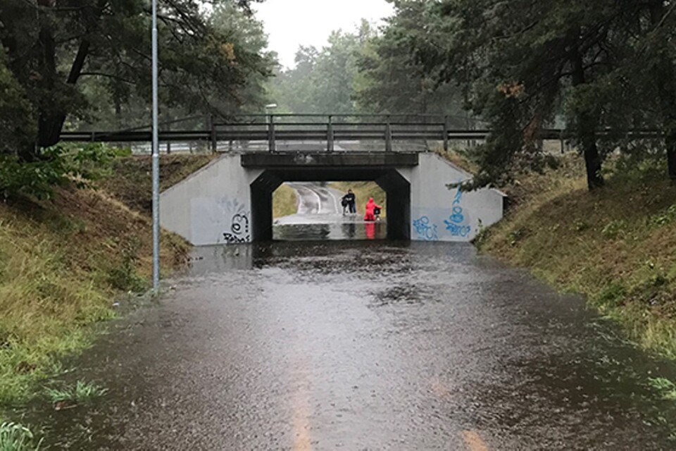 Två cyklister ville ta den kortaste vägen till jobbet trots översvämning i tunneln under Ölandsleden i södra Berga. Vattnet stod knädjupt i cykeltunneln. En av cyklisterna var väl förberedda med ombyte efter den blöta cykelturen.