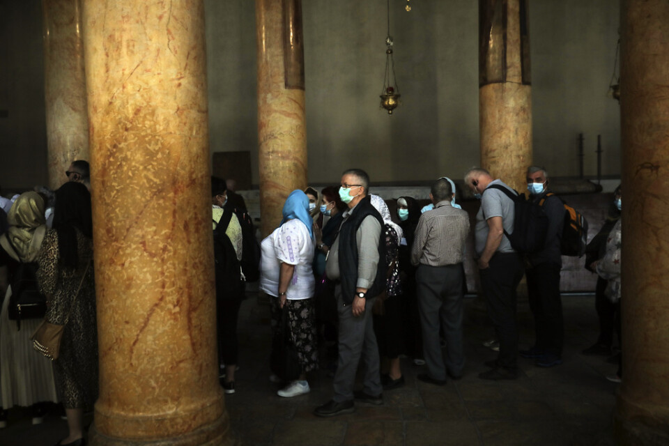 Människor besöker Födelsekyrkan i Betlehem. Nu stängs kyrkan på grund av coronaviruset under de kommande två veckorna.