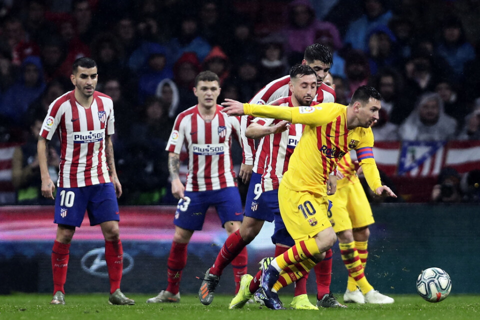 Lionel Messi, i gult matchställ, skickade i och med sitt sena mål mot Atlético Madrid upp Barcelona i topp i La Liga.