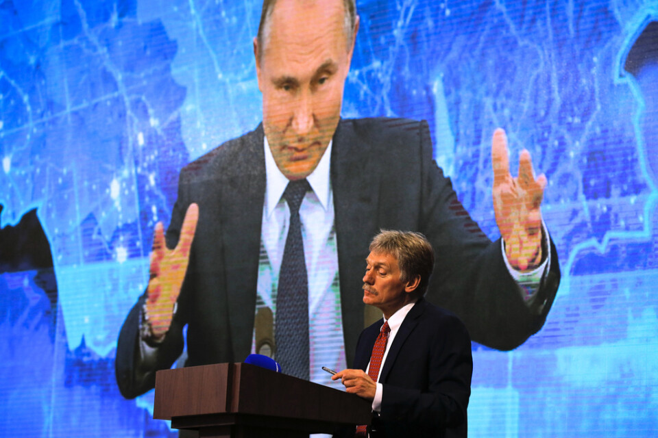 Kremls talesperson Dmitrij Peskov tittar på medan president Vladimir Putin talar via länk under en pressträff. Arkivbild.