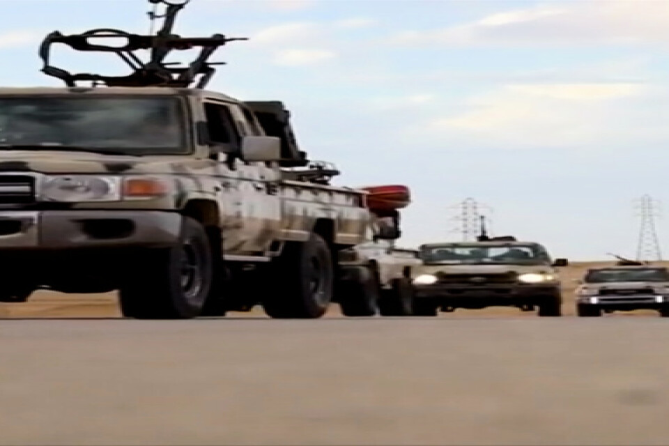 En fordonskolonn med vapen på en väg i Libyen. Bilden är från en tv-sändning.