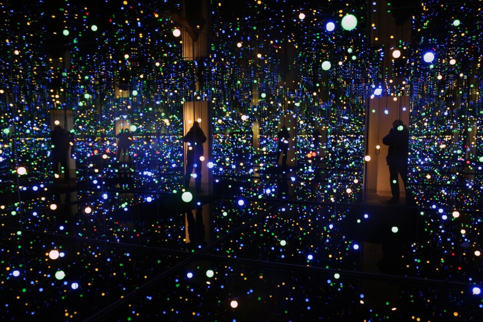 Yayoi Kusamas ”Gleaming Lights of the Souls” är vatten, speglar och ljus som ändrar färg. Fotografen står i dörröppningen till en av Louisianas fasta utställningar.