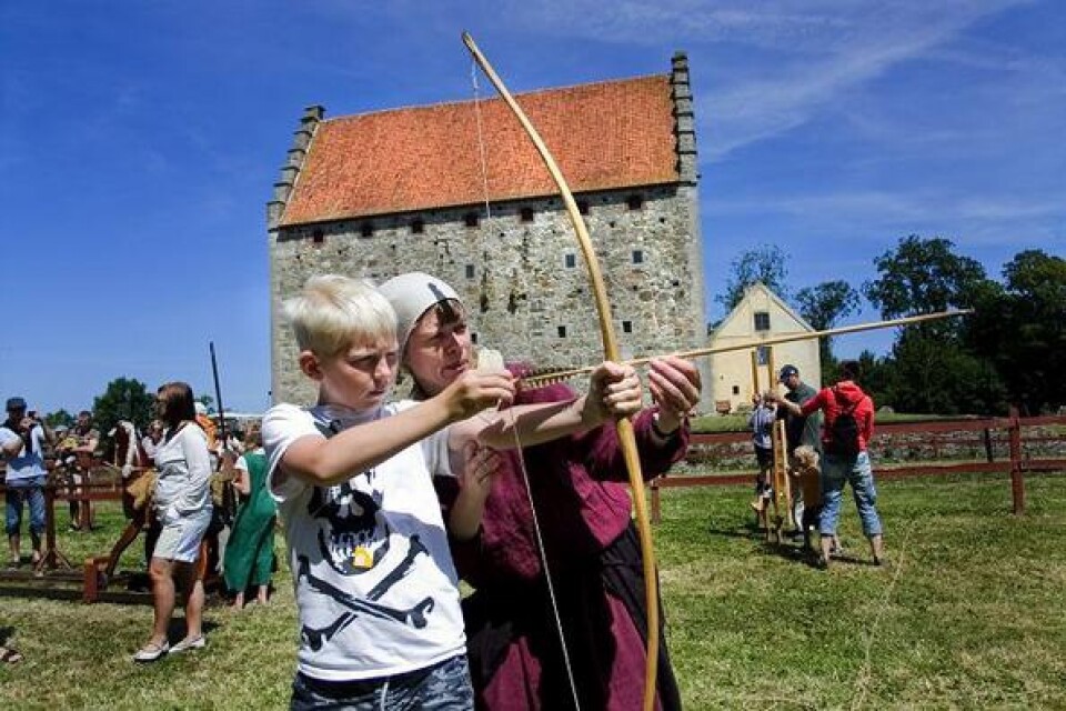 Oscar Eriksson, tio år, från Hörbytrakten fick en lektion i bågskytte av Oline Sörensen, museivärd på medeltidsborgen Glimmingehus. bild: gustav wennerholm
