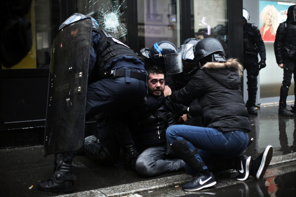 En man grips av kravallpoliser i Paris i samband med demonstrationerna.