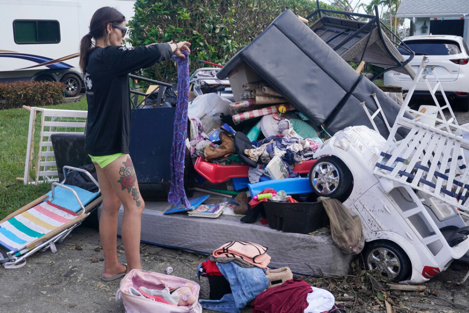 En kvinna i Fort Myers letar efter kläder och skor till sin familj under måndagen. Hennes hem blev helt förstört i en översvämning som orsakades av orkanen Ian förra veckan.