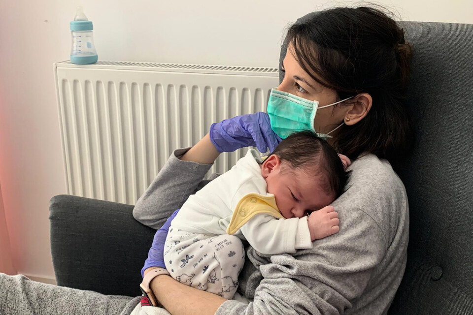 Vanesa Muro i Madrid håller sin nyfödde son Oliver. Än har hon, eller barnets pappa Oscar Carrillo, inte kunnat röra vid sonen utan plasthandskar av rädsla för att smitta honom med coronaviruset.