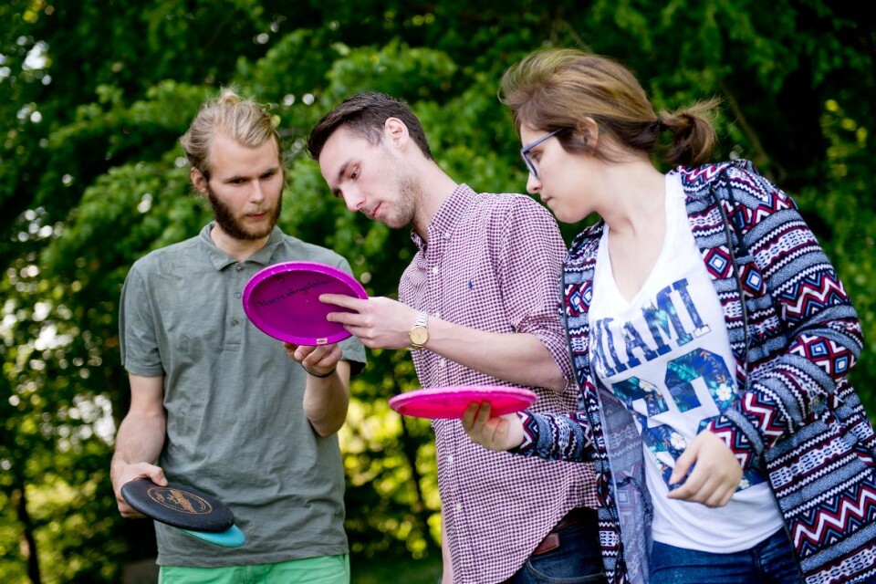 Frisbeegolfproffset Emil Söderstrand ger tips till elevstödjarna Mikael Holmgren och Lina Subina.