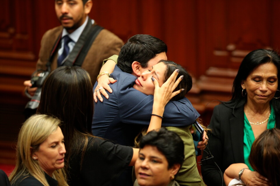 Parlamentsledamöter i Peru firar efter att ha röstat för att avsätta president Pedro Castillo.