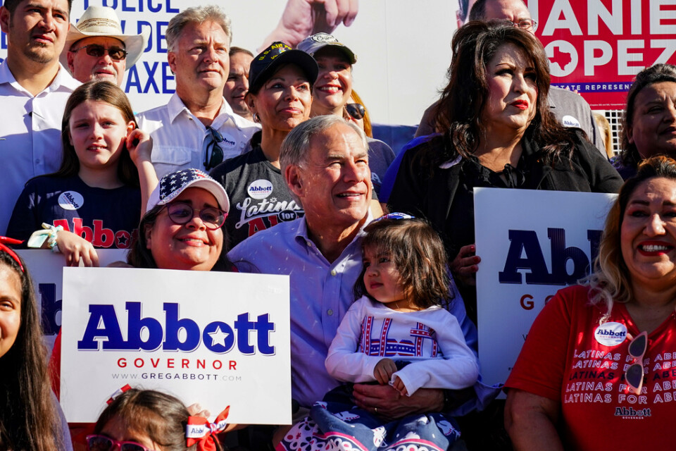 Texasguvernören Greg Abbott (i mitten med ett barn i famnen) har Donald Trumps stöd, trots att det tisslas och tasslas om möjliga presidentambitioner. Arkivbild.