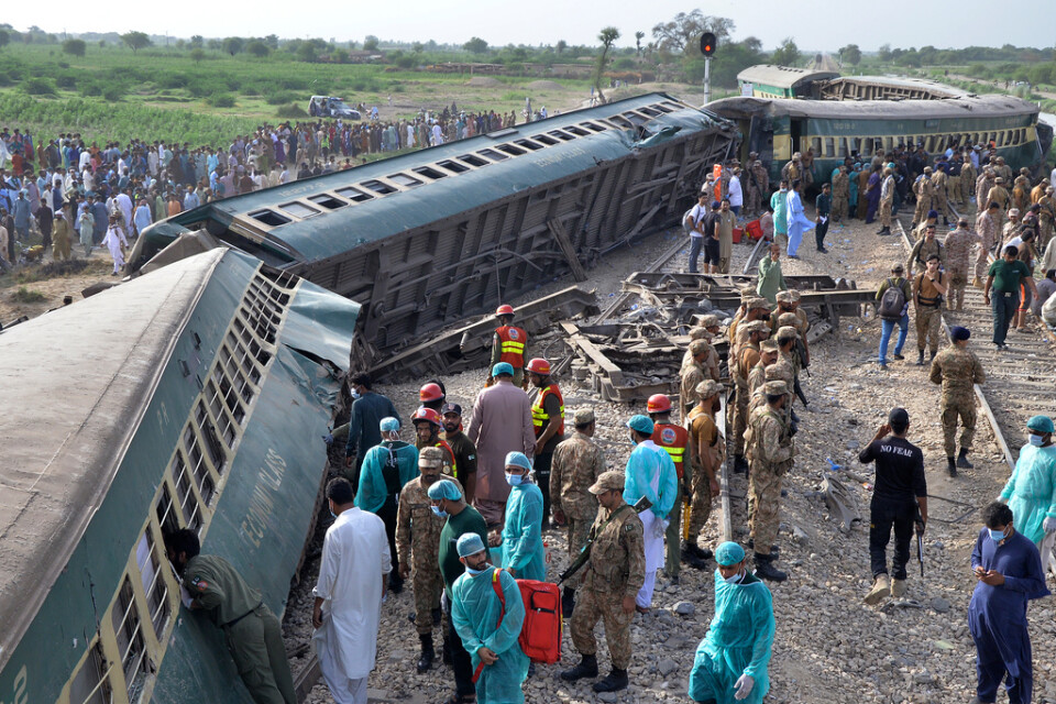 Räddningstjänst och militär på olycksplatsen, nära en järnvägsstation i staden Nawabshah i Sindh-provinsen.