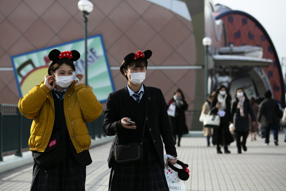 Två besökare vid Disneyland i Tokyo, innan parken stängde. Arkivbild.