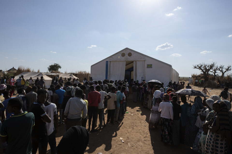 Tusentals människor flydde från Tigray i Etiopien när konflikten bröt ut i november. Här köar män och kvinnor för hjälp i ett flyktingläger i Sudan i december.