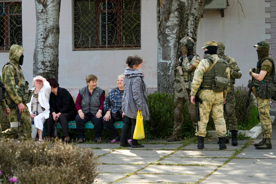 Äldre boende i ockuperade Cherson pratar med ryska soldater. Bilden togs under en rundtur som organiserades av det ryska ockupationsstyret. Arkivbild.