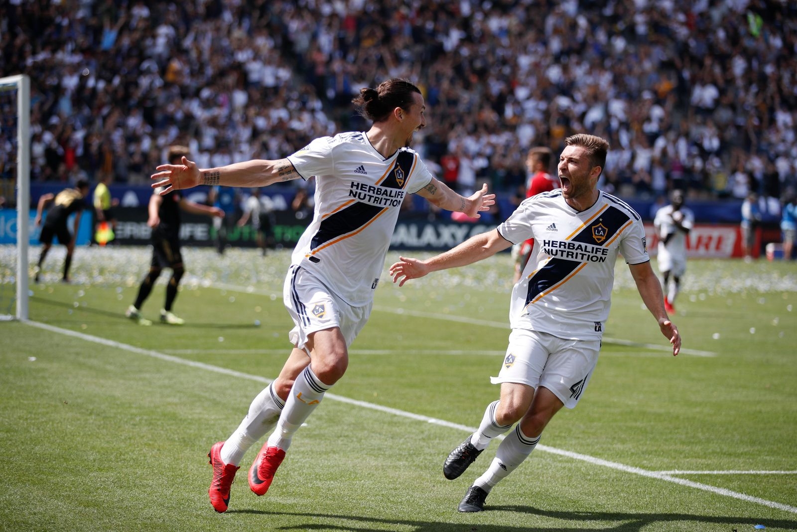 Los Angeles Galaxy's Zlatan Ibrahimovic, left, of Sweden, celebrates his second goal of the game with Dave Romney during the second half of an MLS soccer match against the Los Angeles FC Saturday, March 31, 2018, in Carson, Calif. The Galaxy won 4-3. (AP Photo/Jae C. Hong)