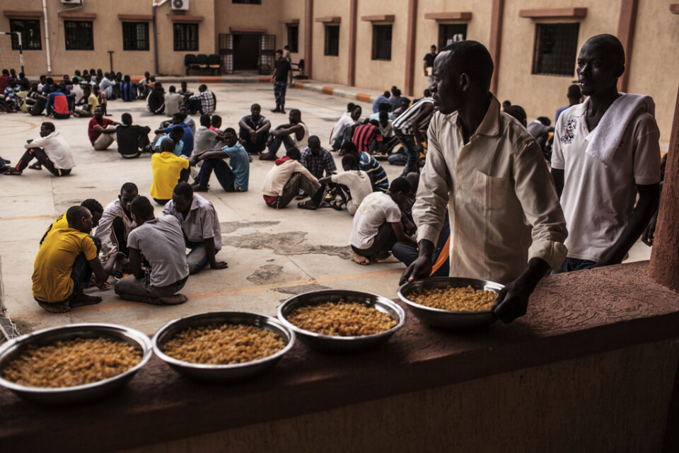 Arkivbild. En migrant håller en skål med pasta under en lunch i ett flyktingförvar i Libyen.