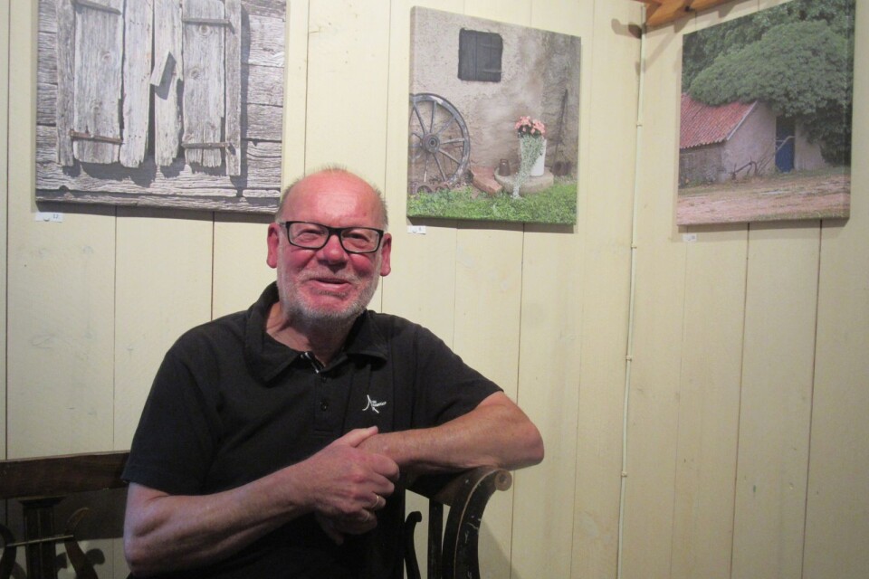 Björn Sandström i kaffestugan på Himmelsberga med tre av sina canvasfoton bakom sig.