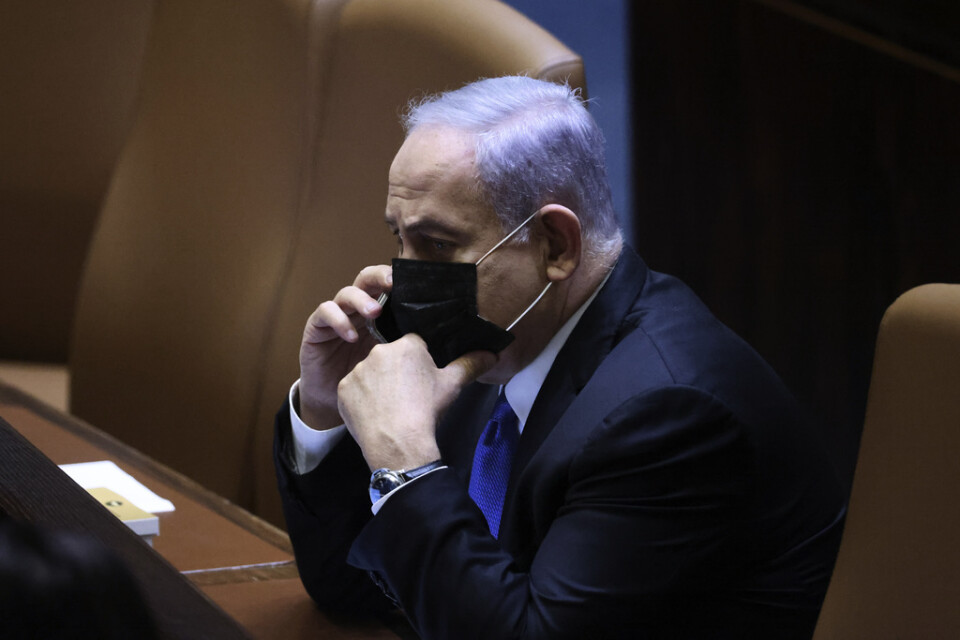 Benjamin Netanyahu med telefon i handen då Israels parlamentariker på onsdagen röstade fram en ny president.