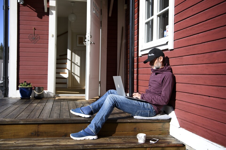 Man med bärbar dator jobbar hemifrån på sin altan. Arkivbild.