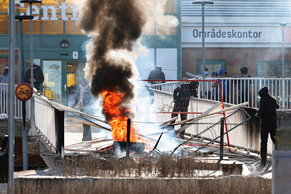 Personer gör en barrikad med brinnande bildäck och andra föremål vid upploppen i Navestad i Norrköping på påskdagen. Arkivbild.