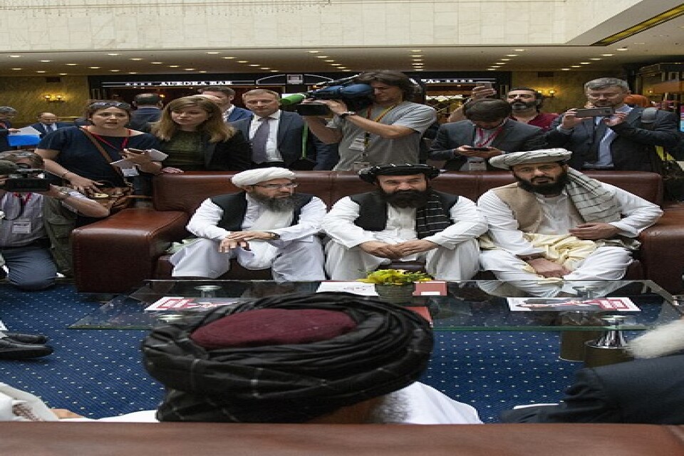 Representanter från talibanrörelsen talar med reportrar under fredssamtal i juni i år.