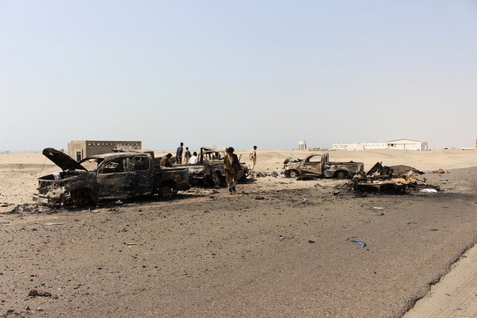 En sydjemenitisk separatistsoldat undersöker rester av fordon som tillhörde regeringsstyrkor, efter att de träffats i emiratiska luftanfall.