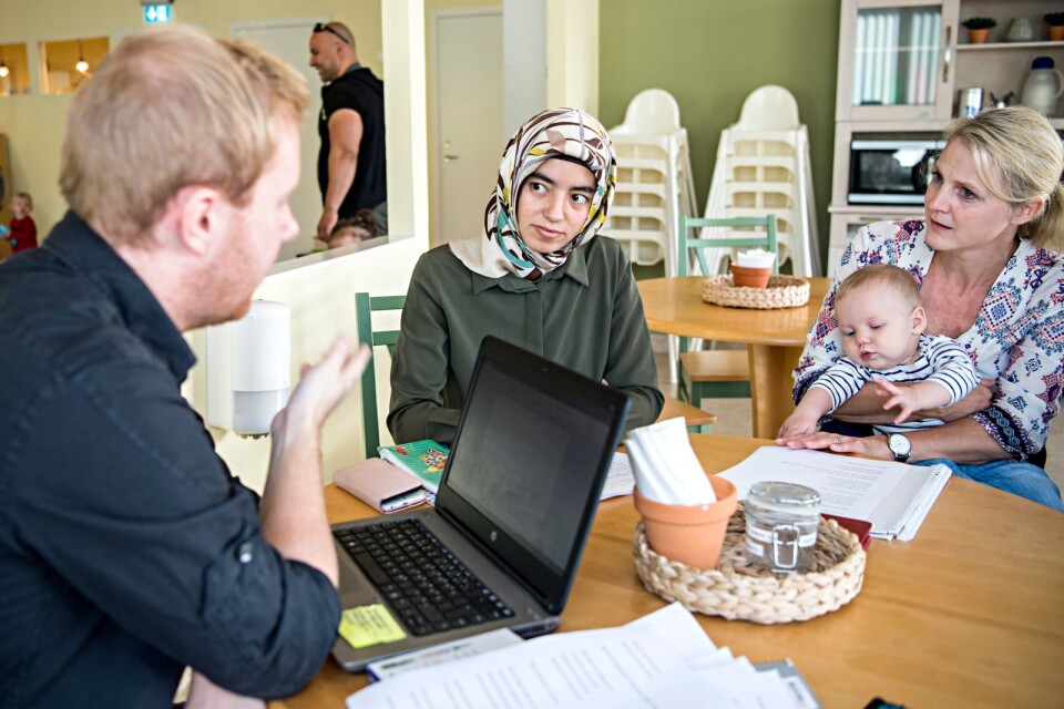 SFI-läraren Henrik Holgersson lär föräldrarna svenska bättre på Öppna förskolan. Här lyssnar Cavide Cihonsir och Dorthe Funk med stort intresse på vad han säger.