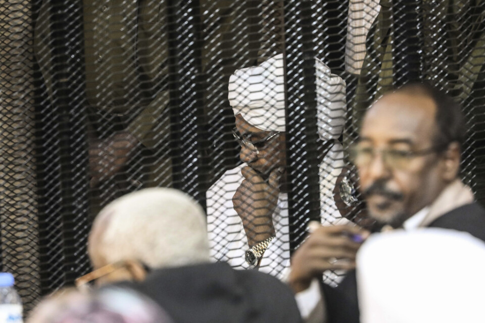 Sudans tidigare president Omar al-Bashir sitter i en stålbur i rättssalen. Bilden är från den 24 augusti.