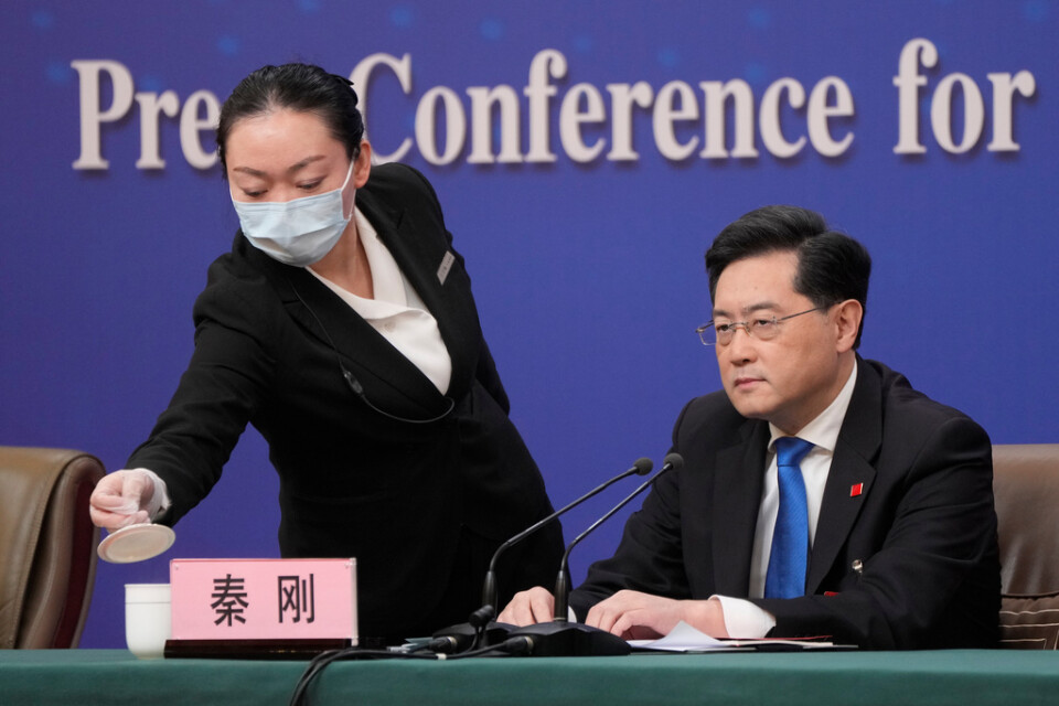 En anställd ser till Qin Gangs kopp vid hans presskonferens på tisdagen.