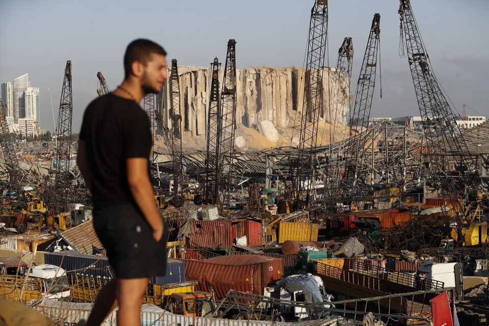 En man tittar ut över förödelsen efter tisdagens explosion i Beiruts hamn.